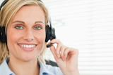 Close up of a smiling businesswoman with headset looking into camera