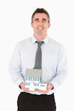 Businessman holding a miniature house