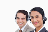 Close up side view of smiling telephone support employees at work