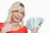 Woman winking an eye while pointing her finger on dollar notes