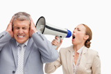 Businesswoman screaming with a megaphone at her colleague