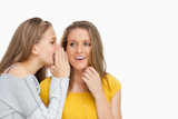 Blonde student whispering to her beautiful friend