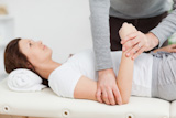 Woman lying on a table while being manipulated