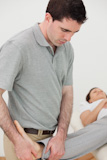 Chiropractor massaging the leg of a woman