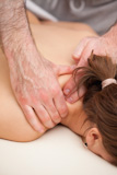 Chiropractor squeezing the shoulder of woman while massaging