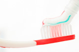 Red toothbrush next to a tube of toothpaste