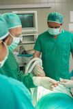 Surgeon and a team operating a sleeping patient