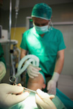 Oxygen mask placed in the face of a patient while a medical team is working