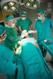 Team of surgeons using scalpel to open a patient