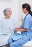 Elderly patient holding the hand of a nurse