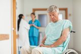 Male patient in a wheelchair next to nurses