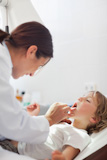 Doctor auscultating the mouth of a child