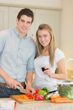 Couple looking at tablet pc while cooking