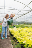 Gardener with granddaughter in greenhouse