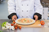 Chef holding up pizza