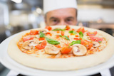 Chef holding mushroom pizza