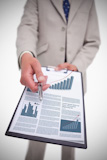 Happy businessman holding a panel showing graph
