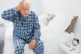 Elderly man suffering on the bed