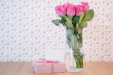 Bouquet,of,pink,roses,in,vase,with,pink,gift,and,blank,card