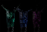 Serial arrangement of coloured liquids splashing in cocktail glass