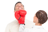 Businesswoman punching businessman with boxing gloves