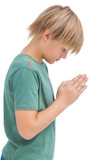 Little boy saying his prayers side view