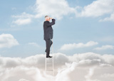 Businessman standing on ladder over the clouds