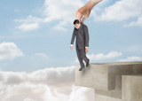 Businessman standing on a ladder over clouds