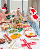 Family,in,santas,hats,toasting,wine,glasses,at,dining,table
