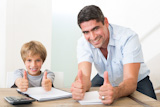 The father and son who express the thumb by gesture while carrying out homework