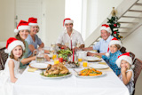 The happy family in the hat of the Santa Claus who takes a Christmas meal