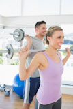 Fit woman and man lifting weights