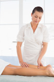 Female masseur massaging woman's leg